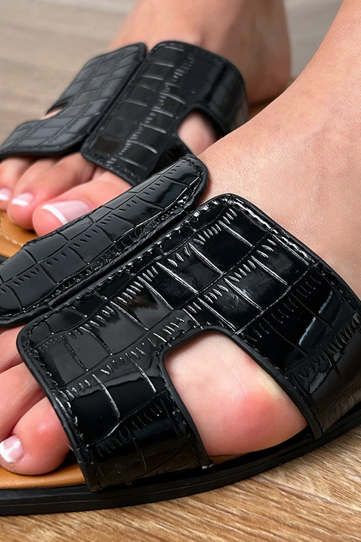 Tongs noires à semelle plate avec... Tongs noires à semelle plate avec...