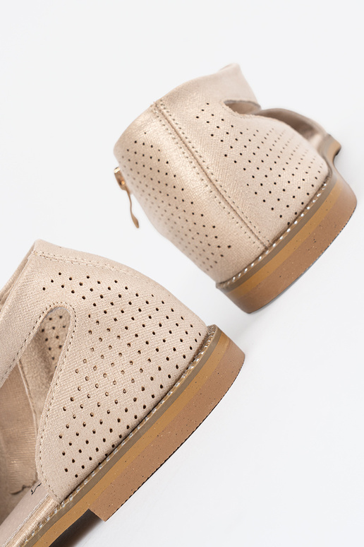 couleur dorée des sandales ajouré sur une semelle plate